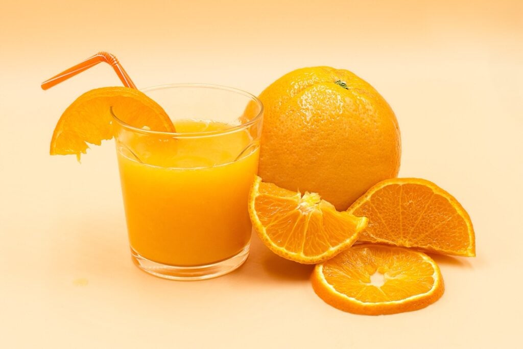 Glas mit Orangensaft und Orangen